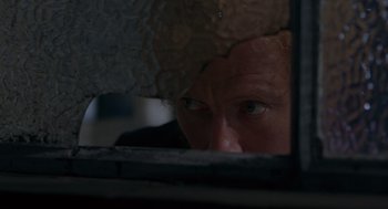 Movie still from “Frenzy” (1972), directed by Alfred Hitchcock – A man looking through a window at a building; Extreme Close Up shot, Low angle
