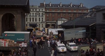 Movie still from “Frenzy” (1972), directed by Alfred Hitchcock – A group of people standing next to a truck; Extreme Wide shot, High angle