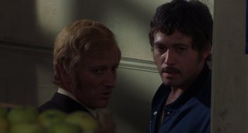 Movie still from “Frenzy” (1972), directed by Alfred Hitchcock – Two men standing next to each other in front of a wall; Close Up shot, Over the shoulder angle