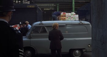 Movie still from “Frenzy” (1972), directed by Alfred Hitchcock – A woman standing on the hood of a van; Wide shot, Over the shoulder angle