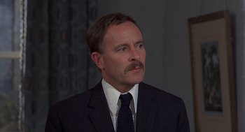 Movie still from “Frenzy” (1972), directed by Alfred Hitchcock – A person wearing a suit and a tie; Close Up shot, Low angle
