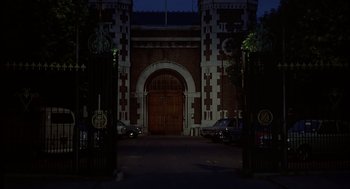 Movie still from “Frenzy” (1972), directed by Alfred Hitchcock – A large building with a large gate at night; Extreme Wide shot, High angle