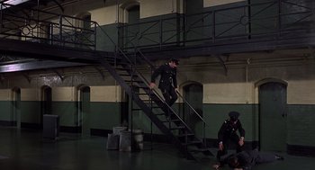 Movie still from “Frenzy” (1972), directed by Alfred Hitchcock – A man in a uniform climbing up a metal staircase; Wide shot, High angle