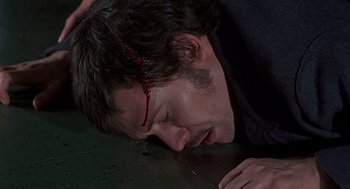 Movie still from “Frenzy” (1972), directed by Alfred Hitchcock – A man with blood on his face is laying on the ground; Close Up shot, High angle