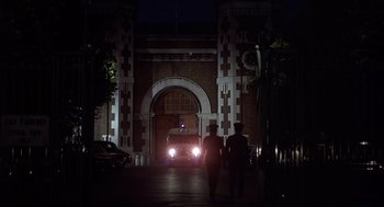 Movie still from “Frenzy” (1972), directed by Alfred Hitchcock – Two people are walking down the street in front of a building; Extreme Wide shot, Low angle
