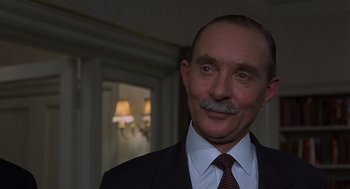 Movie still from “Frenzy” (1972), directed by Alfred Hitchcock – A person wearing a suit and tie; Close Up shot, Low angle