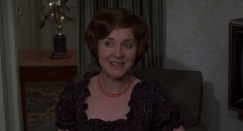Movie still from “Frenzy” (1972), directed by Alfred Hitchcock – A person sitting on a couch wearing a dress; Close Up shot, High angle