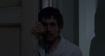 Movie still from “Frenzy” (1972), directed by Alfred Hitchcock – A man leaning against a wall in a dark room; Close Up shot, Low angle