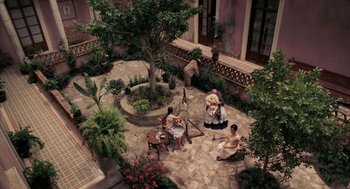 Movie still from “Frida” (2002), directed by Julie Taymor – An aerial view of people sitting in a courtyard; Extreme Wide shot, High angle