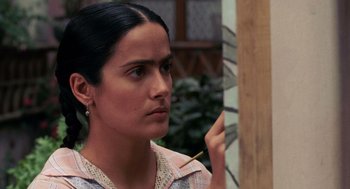 Movie still from “Frida” (2002), directed by Julie Taymor – A woman holding a paintbrush in front of a painting; Close Up shot, Over the shoulder angle