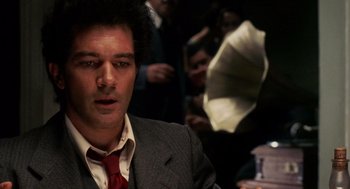 Movie still from “Frida” (2002), directed by Julie Taymor – A person wearing a suit and tie; Close Up shot, Low angle