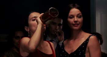 Movie still from “Frida” (2002), directed by Julie Taymor – Two women and a man are drinking wine together; Medium shot, Over the shoulder angle