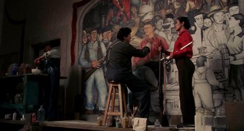 Movie still from “Frida” (2002), directed by Julie Taymor – A man and a woman are painting a mural; Wide shot, Low angle