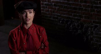 Movie still from “Frida” (2002), directed by Julie Taymor – A woman wearing a red jacket and a black hat; Close Up shot, Over the shoulder angle