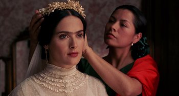 Movie still from “Frida” (2002), directed by Julie Taymor – A woman putting a crown on a woman's head; Close Up shot, Over the shoulder angle