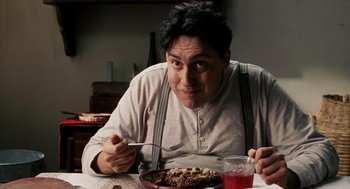 Movie still from “Frida” (2002), directed by Julie Taymor – A man sitting at a table eating food; Close Up shot, Over the shoulder angle