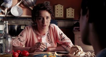 Movie still from “Frida” (2002), directed by Julie Taymor – A woman sitting at a table holding a coffee cup; Close Up shot, Over the shoulder angle