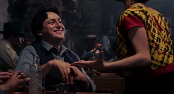 Movie still from “Frida” (2002), directed by Julie Taymor – A man sitting in front of a woman at a table; Medium shot, Over the shoulder angle