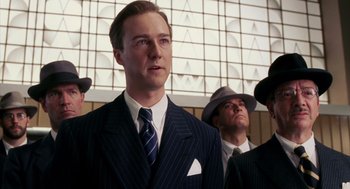 Movie still from “Frida” (2002), directed by Julie Taymor – A man in a suit and tie standing next to another man; Medium shot, Low angle