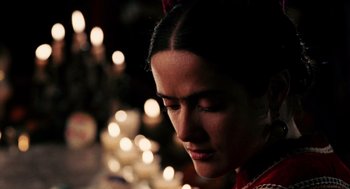 Movie still from “Frida” (2002), directed by Julie Taymor – A person with a candle in the background; Close Up shot, Over the shoulder angle