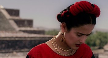 Movie still from “Frida” (2002), directed by Julie Taymor – A woman in a red dress with a red turban on her head; Close Up shot, Over the shoulder angle
