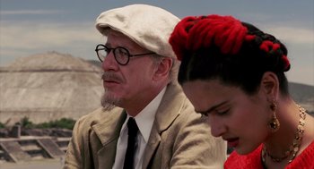Movie still from “Frida” (2002), directed by Julie Taymor – An older man and a young woman sitting next to each other; Close Up shot, Over the shoulder angle