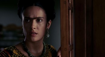 Movie still from “Frida” (2002), directed by Julie Taymor – A person wearing a necklace and earrings; Close Up shot, Over the shoulder angle
