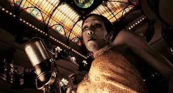 Movie still from “Frida” (2002), directed by Julie Taymor – A woman in a yellow dress standing under a stained glass window; Close Up shot, Low angle