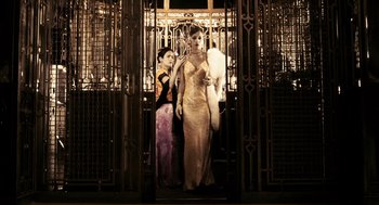 Movie still from “Frida” (2002), directed by Julie Taymor – Two women in evening wear standing in front of an iron gate; Wide shot, Low angle