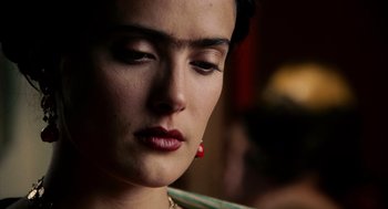 Movie still from “Frida” (2002), directed by Julie Taymor – A person wearing a red earring; Close Up shot, Over the shoulder angle