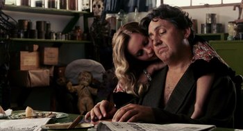 Movie still from “Frida” (2002), directed by Julie Taymor – A man and a woman sitting in front of a newspaper; Medium shot, Low angle