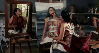 Movie still from “Frida” (2002), directed by Julie Taymor – A woman is painting a picture of a woman in bondage; Medium shot, Overhead angle