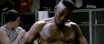 Movie still from “Friday Night Lights” (2004), directed by Peter Berg – A shirtless man with his hand on his shoulder; Close Up shot, Over the shoulder angle