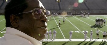 Movie still from “Friday Night Lights” (2004), directed by Peter Berg – An old man with glasses is looking into the distance; Extreme Close Up shot, Low angle