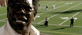Movie still from “Friday Night Lights” (2004), directed by Peter Berg – A man's face with a baseball field in the background; Extreme Close Up shot, High angle