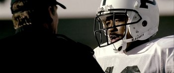 Movie still from “Friday Night Lights” (2004), directed by Peter Berg – A football player is talking to a referee; Close Up shot, Over the shoulder angle