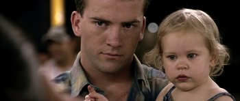 Movie still from “Friday Night Lights” (2004), directed by Peter Berg – A person and a child; Close Up shot, Over the shoulder angle