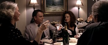 Movie still from “Friday Night Lights” (2004), directed by Peter Berg – A group of people sitting at a dinner table drinking wine; Medium shot, Overhead angle