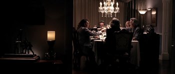 Movie still from “Friday Night Lights” (2004), directed by Peter Berg – A group of people sitting at a dinner table; Wide shot, High angle