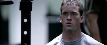 Movie still from “Friday Night Lights” (2004), directed by Peter Berg – A man that is looking at the camera; Close Up shot, Low angle