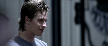 Movie still from “Friday Night Lights” (2004), directed by Peter Berg – A young man with wet hair looking to his left; Close Up shot, Over the shoulder angle