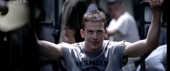 Movie still from “Friday Night Lights” (2004), directed by Peter Berg – A young man is posing for a picture; Close Up shot, Over the shoulder angle