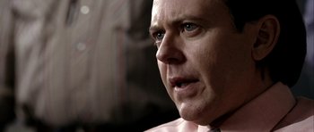 Movie still from “Friday Night Lights” (2004), directed by Peter Berg – A man's face in a pink shirt; Close Up shot, Over the shoulder angle