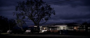 Movie still from “Friday Night Lights” (2004), directed by Peter Berg – A house with a tree in front of it at night time; Extreme Wide shot, Low angle
