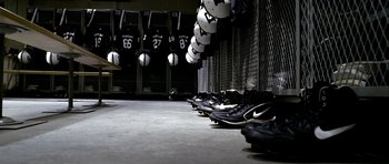 Movie still from “Friday Night Lights” (2004), directed by Peter Berg – A bunch of soccer balls hanging in a locker room; Wide shot, High angle