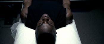 Movie still from “Friday Night Lights” (2004), directed by Peter Berg – A man laying on top of a bed with his eyes closed; Close Up shot, Overhead angle