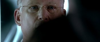 Movie still from “Friday Night Lights” (2004), directed by Peter Berg – An older man wearing glasses looking at the camera; Extreme Close Up shot, Over the shoulder angle