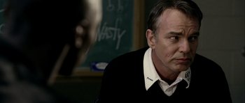 Movie still from “Friday Night Lights” (2004), directed by Peter Berg – A person sitting in front of a chalkboard; Close Up shot, Over the shoulder angle