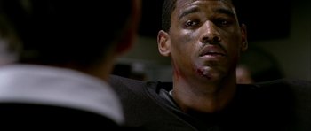 Movie still from “Friday Night Lights” (2004), directed by Peter Berg – A man with blood on his face looking at another man with blood on his face; Close Up shot, Low angle