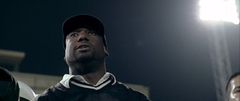 Movie still from “Friday Night Lights” (2004), directed by Peter Berg – A person wearing a hat; Close Up shot, Low angle